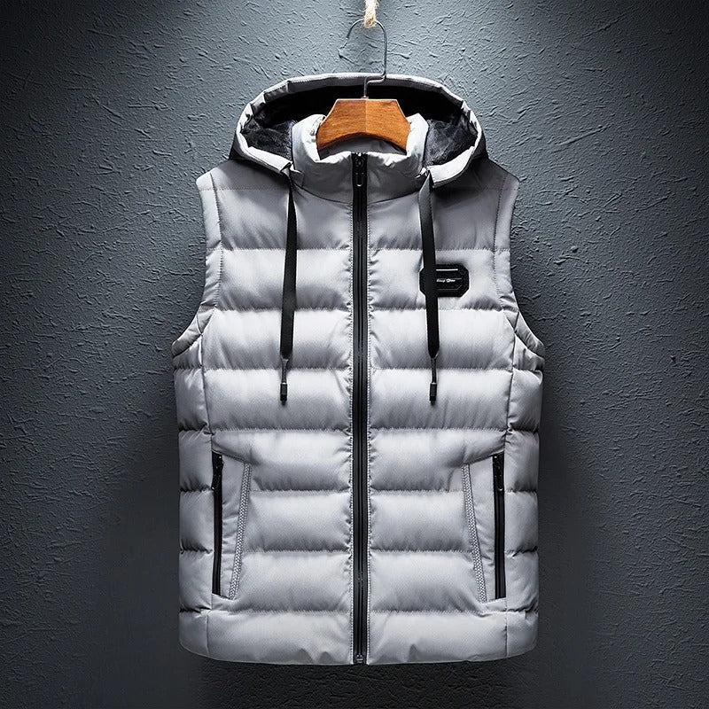 Een stijlvolle gewatteerde bodywarmer van ZachtKern in een frisse grijze kleur. Het vest heeft een capuchon en praktische zakken, ideaal voor een comfortabele en modieuze uitstraling tijdens koude dagen.