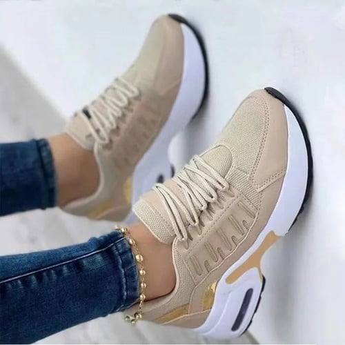 En paar beige sneakers met een stijlvolle en moderne uitstraling, voorzien van ademend mesh materiaal en gouden details. De sneakers zijn ontworpen met orthopedische zolen voor maximaal comfort en ondersteuning, waardoor ze ideaal zijn voor dagelijks gebruik. De sneakers zijn gecombineerd met een casual outfit, perfect voor een comfortabele, modieuze look. Het ontwerp is zowel trendy als functioneel, met een focus op voetondersteuning en langdurig draagcomfort.