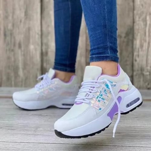 Een paar elegante witte sneakers met pastelkleurige accenten in lila en een holografisch effect op de bovenkant. Deze sneakers bieden een orthopedisch ontwerp voor extra ondersteuning en comfort bij elke stap. De ademende stof en de lichtgewicht zool zorgen voor een perfecte pasvorm, ideaal voor dagelijks gebruik en lange wandelingen. Het moderne ontwerp voegt een stijlvolle touch toe aan elke casual outfit.