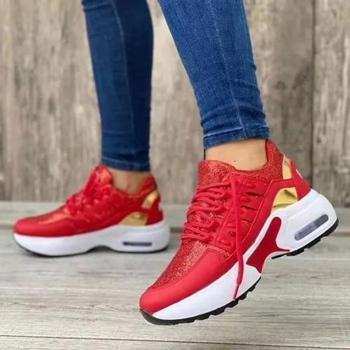 Een paar opvallende rode sneakers met gouden details en een witte zool. Het design biedt orthopedisch comfort met ademende materialen en een lichtgewicht, ondersteunende zool. Deze sneakers combineren stijl en functionaliteit, perfect voor dagelijks gebruik en lange wandelingen, en geven je outfit een sportieve uitstraling met extra comfort.
