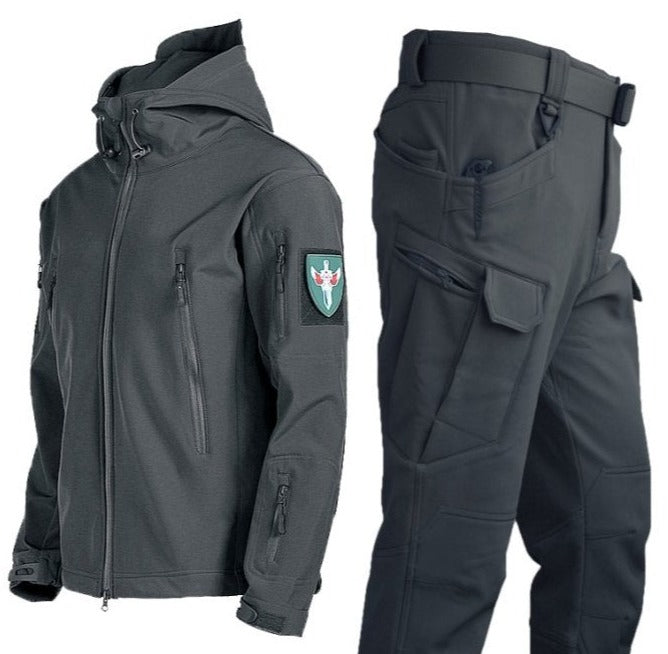 Een donkergrijs waterdicht regenjack met bijpassende broek, ontworpen voor een moderne en functionele uitstraling. Het jack heeft een capuchon en meerdere ritszakken voor handige opbergruimte, terwijl de broek een comfortabele pasvorm biedt met praktische zakken. Perfect voor bescherming tegen het weer tijdens buitenactiviteiten of dagelijks gebruik.