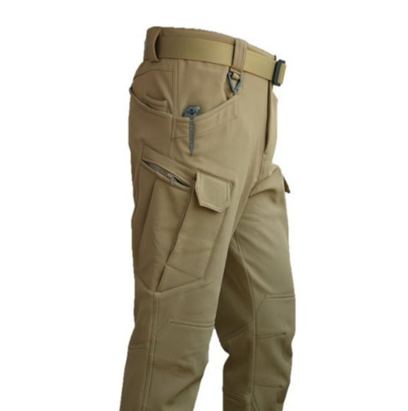 Een close-up van de donkergrijze Zenova RegenSet broek, die de functionaliteit benadrukt met rits- en cargozakken, ideaal voor regenachtig weer.