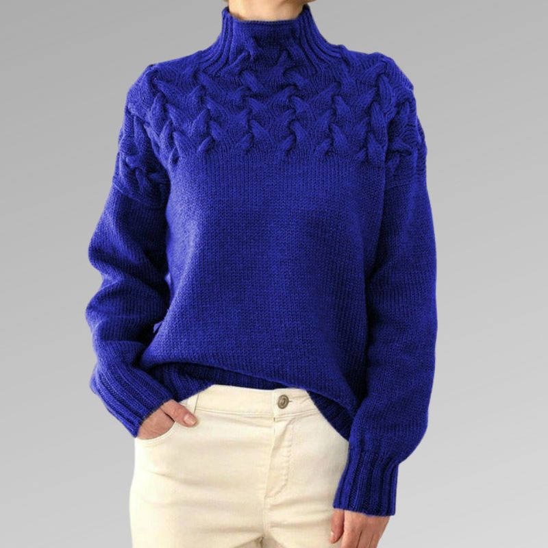 Zimora veelzijdige casual trui in kobaltblauw, met een elegant gevlochten patroon op de schouders en een hoge kraag. De trui heeft een comfortabele pasvorm en lange mouwen, perfect voor zowel een casual als chique uitstraling. Ideaal te combineren met lichte broeken voor een modieuze en tijdloze look.
