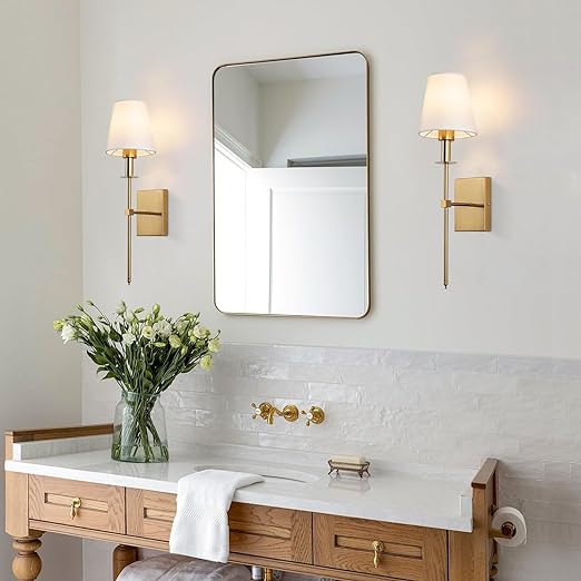 De Aurelia Wall Light in klassiek gouden ontwerp, met een witte lampenkap, biedt een elegante verlichting voor de badkamer, perfect voor een verfijnde en sfeervolle uitstraling.