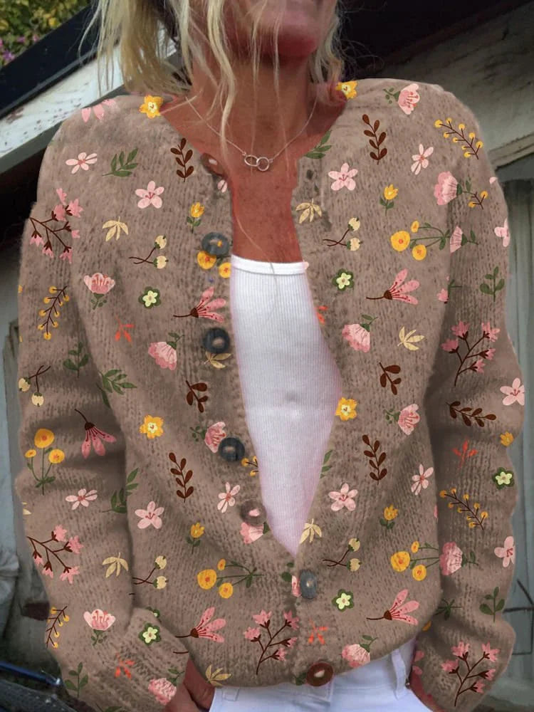 Betina cardigan met een bruin bloemenpatroon, gedragen door een vrouw. De cardigan heeft een warme, comfortabele pasvorm met knopen aan de voorkant. Het is een stijlvolle en veelzijdige toevoeging aan je garderobe voor een casual look.