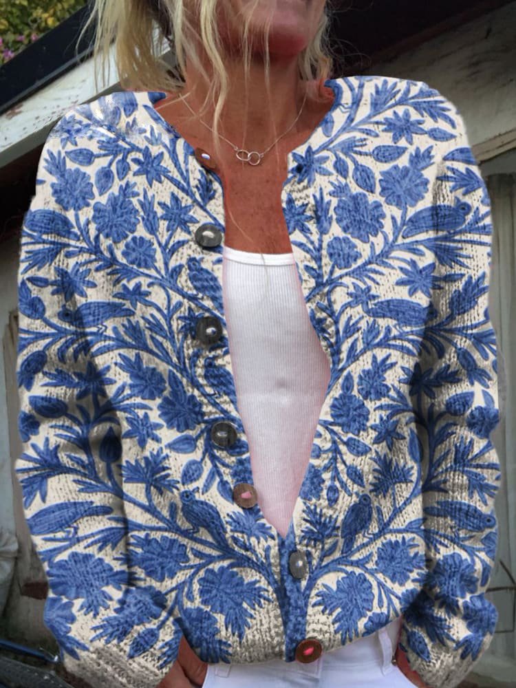 Betina cardigan met blauw-wit bloemenpatroon, gedragen door een vrouw. De cardigan heeft een comfortabele pasvorm, knoopsluiting en een elegante uitstraling. Perfect voor zowel casual als chique gelegenheden.