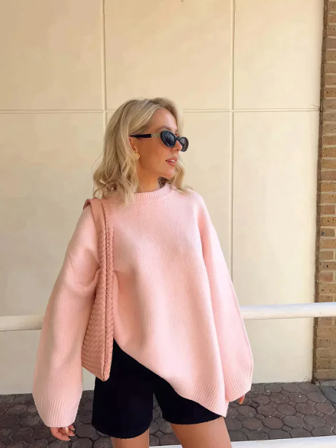 De Blissta trui in zachtroze biedt een stijlvolle, comfortabele pasvorm. De trui heeft een relaxte snit met brede mouwen en een klassieke ronde hals, perfect voor een casual, modieuze look. Gecombineerd met shorts en een tas, is het een ideale keuze voor een casual maar chique outfit.
