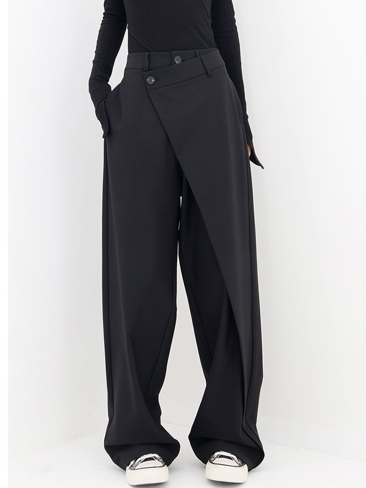 Stijlvolle zwarte wijde broek met een asymmetrisch overlappend ontwerp. De hoge taille en moderne pasvorm zorgen voor een unieke en veelzijdige look. Perfect voor een trendy en elegante uitstraling.
