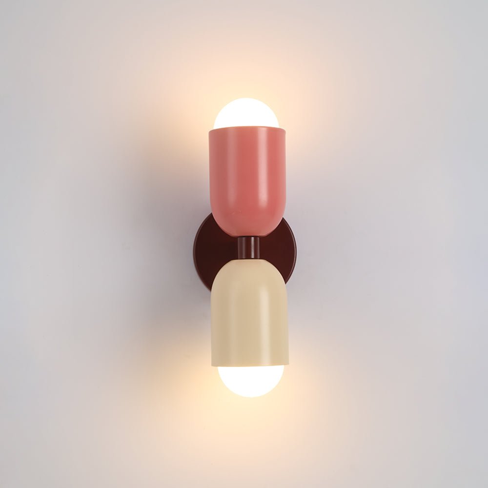 De Glemlux wandlamp, met een moderne Deense stijl, heeft een unieke combinatie van kleuren met een roze en crèmekleurige lampenkap. Het design zorgt voor een speelse maar verfijnde uitstraling, terwijl het zachte licht een warme en gezellige sfeer creëert in elke ruimte.