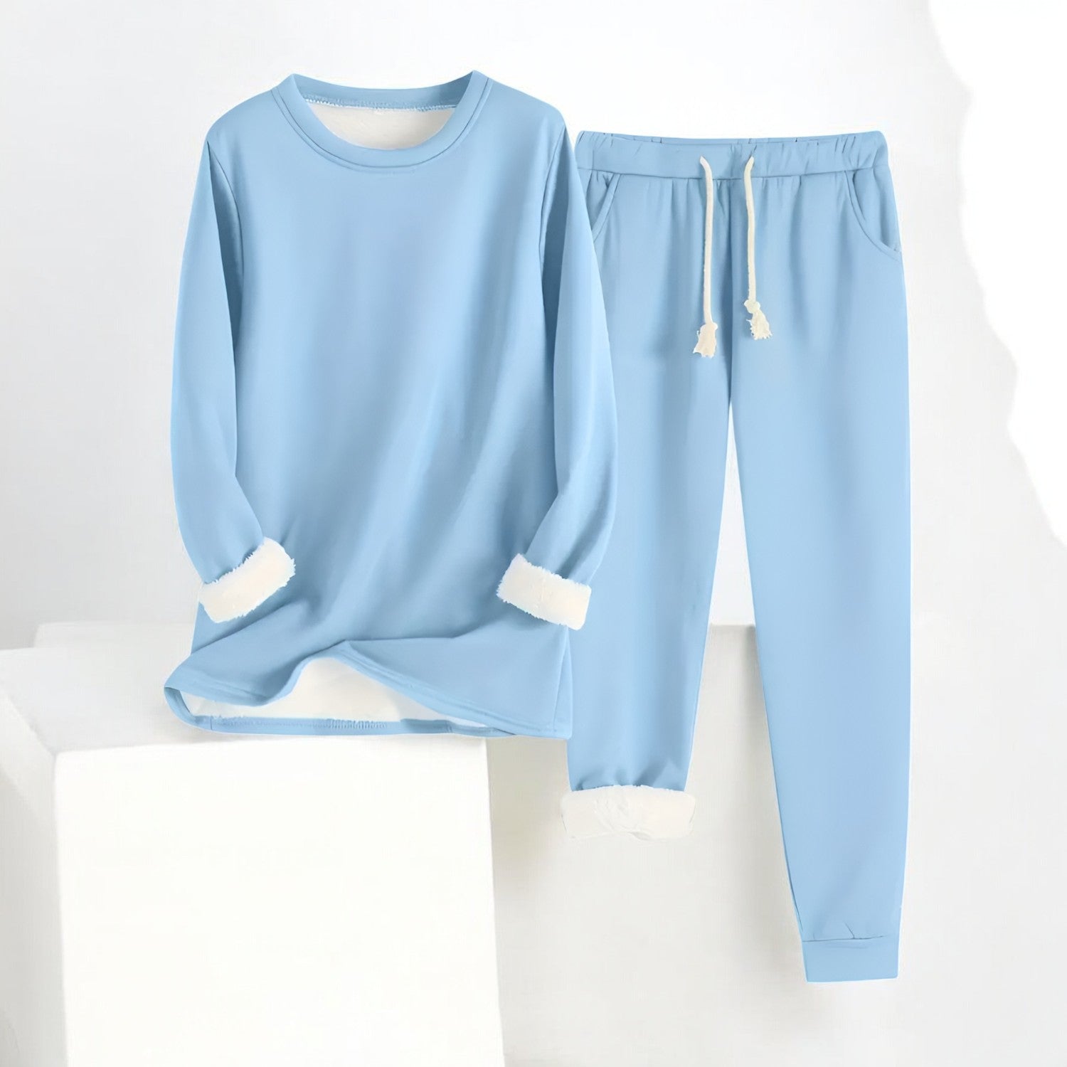 Glorista veelzijdige fleece set in zachtblauw, bestaande uit een comfortabele lange mouwen trui en een bijpassende joggingbroek met trekkoord. De set heeft een warme fleece voering en opgerolde mouw- en broekmanchetten, perfect voor ontspanning en warmte in de koude maanden.