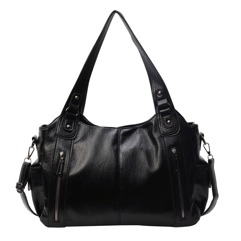 Kaldar stijlvolle leren tas in zwart, met een elegant design en dubbele handvatten. De tas heeft voorvakken met ritssluitingen en een afneembare schouderriem, wat zorgt voor veelzijdigheid en praktische opbergruimte. Perfect voor dagelijks gebruik met een tijdloze uitstraling.
