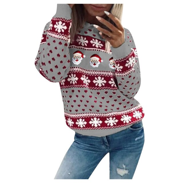 Model draagt een Kardora casual trui met een kerstmotief in grijs en rood. De trui is versierd met schattige kerstmannen, sneeuwvlokken en hartjes, wat zorgt voor een gezellige en feestelijke uitstraling. De comfortabele en warme pasvorm maakt het perfect voor de wintermaanden. Gecombineerd met een jeans voor een trendy en ontspannen look.