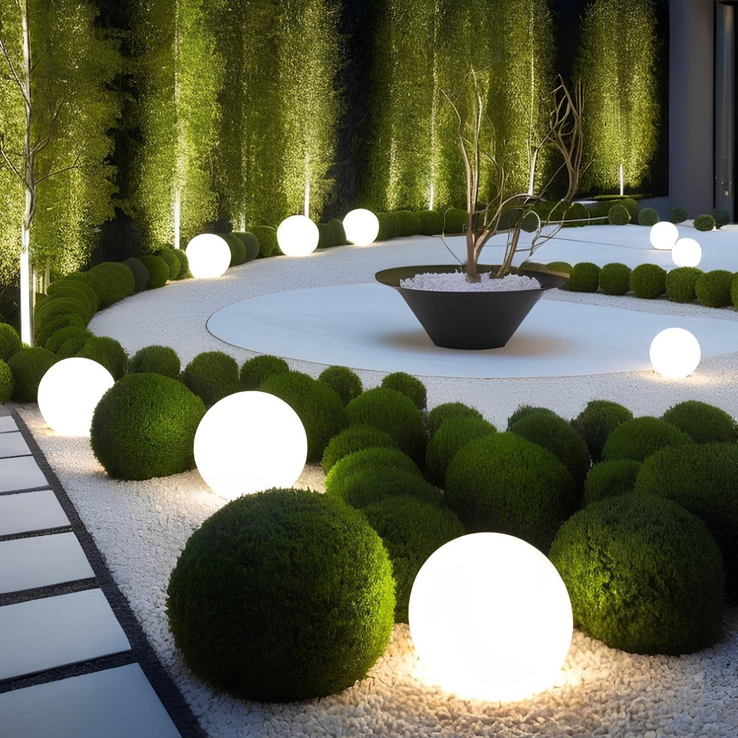 Kendra tuinverlichting met sfeervolle, ronde lichten die de groene buxus en de moderne plantenbak in de tuin accentueren, voor een serene en verlichte buitenomgeving.