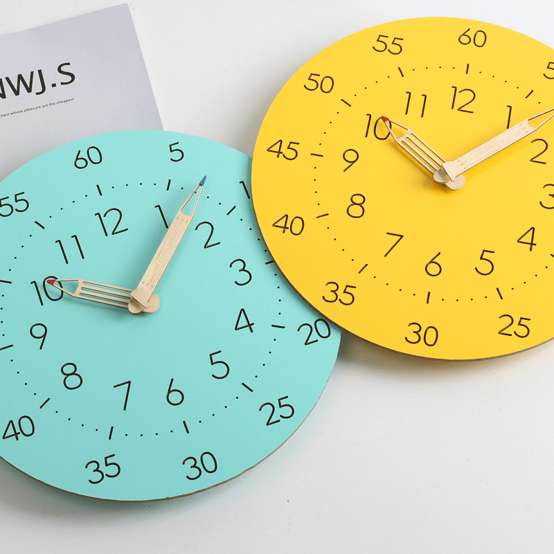  Twee minimalistische wandklokken met een eenvoudig ontwerp. De ene klok heeft een turquoise achtergrond en de andere een gele achtergrond. Beide klokken hebben grote cijfers in zwart, met houten wijzers die een speelse en moderne uitstraling geven. Deze klokken passen perfect in een minimalistisch interieur en zijn zowel functioneel als decoratief.