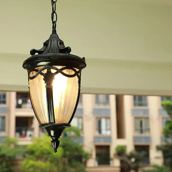Korenia hangende lantaarn met een klassiek zwart frame en zacht, warm licht. Perfect voor veranda's, entrees of overdekte buitenruimtes. De lantaarn hangt aan een stevige ketting en voegt een stijlvolle en tijdloze uitstraling toe aan elke ruimte.