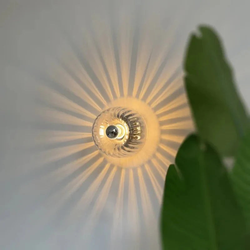 Een close-up van de LumièreAura wandlamp, die een warme en elegante lichtstraal projecteert in een uniek stralenpatroon. Perfect voor een verfijnde en energiezuinige verlichting in moderne interieurs.