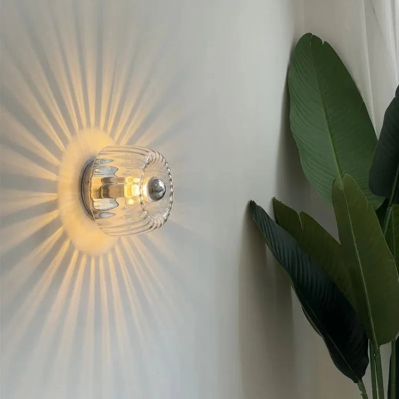 Een elegante LumièreAura wandlamp met een uniek glazen ontwerp dat een schitterend stralenpatroon op de muur projecteert. Perfect voor een energiezuinige en sfeervolle verlichting in moderne interieurs.