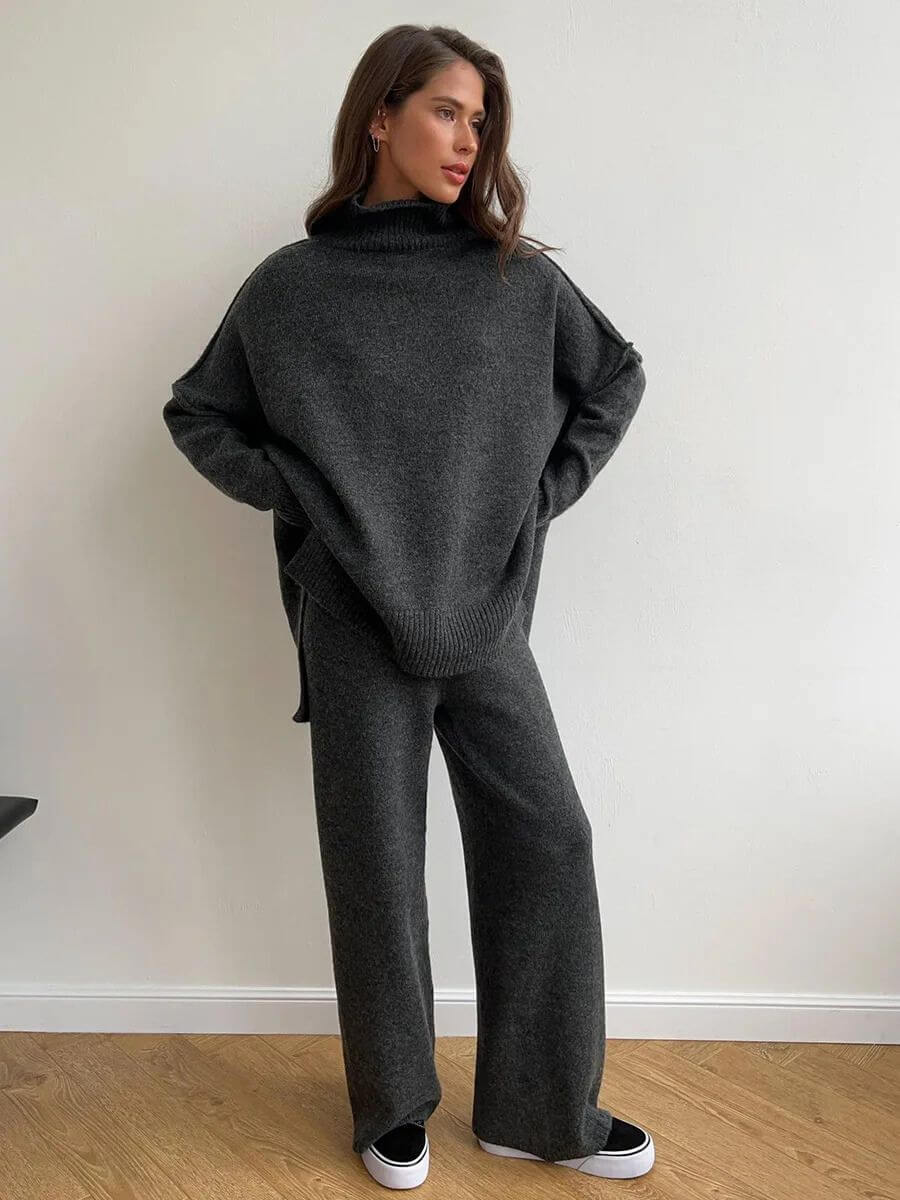 Lumiere stijlvol knit set in donkergrijs, bestaande uit een oversized coltrui en wijde broek. Deze comfortabele en trendy set biedt een elegante uitstraling en is ideaal voor een casual maar chique look. Perfect voor koudere dagen met een relaxte pasvorm.