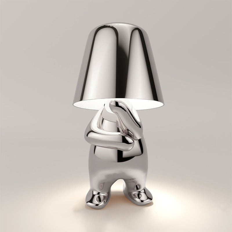 Speelse zilveren Lumineer tafellamp met uniek design, ideaal voor flexibele verlichting en een opvallende toevoeging aan elke moderne ruimte.