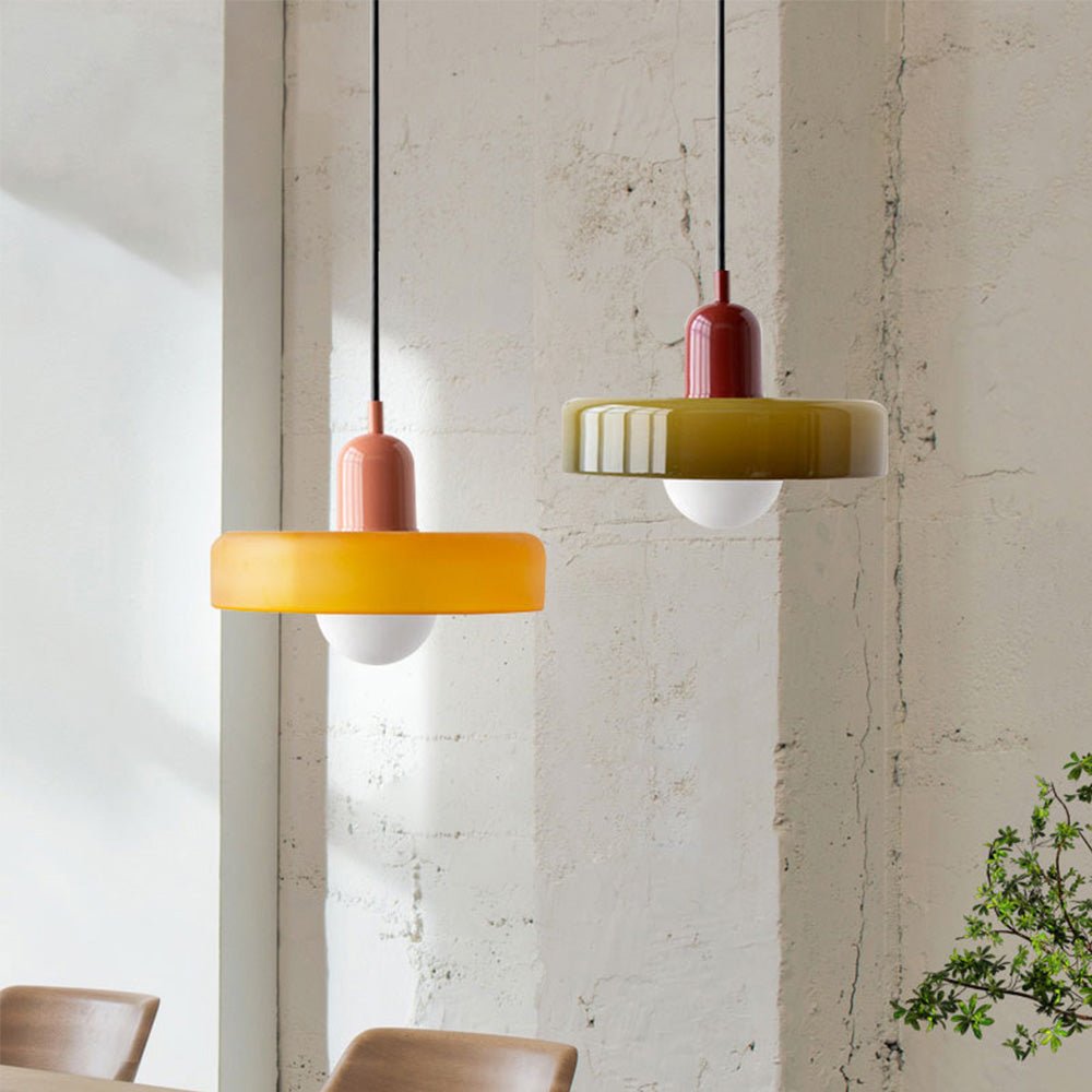 Twee moderne Luminezza Living hanglampen in kleurrijk design, met een unieke combinatie van geel en olijfgroen glas en keramische elementen. Deze stijlvolle lampen voegen een speelse en artistieke touch toe aan elk interieur, ideaal voor boven een eettafel of in een creatieve ruimte.