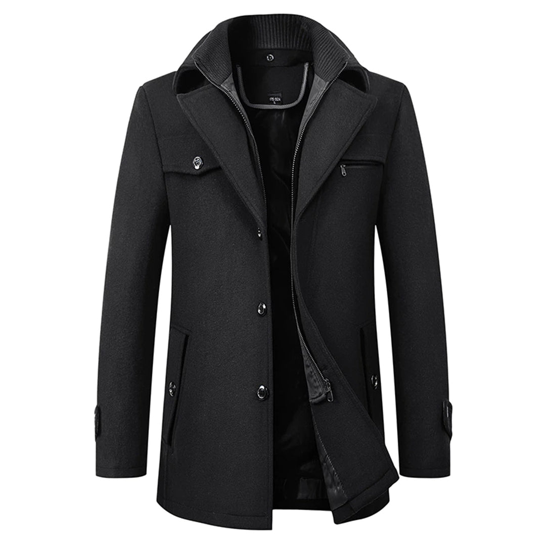 Een stijlvolle en elegante winterjas in donkergrijs, ontworpen om zowel modieus als functioneel te zijn. De jas heeft een dubbele sluiting met zowel knopen als een rits, en een hoog opstaande kraag voor extra warmte en bescherming tegen de kou. De jas biedt een moderne uitstraling en is perfect voor koude winterdagen.