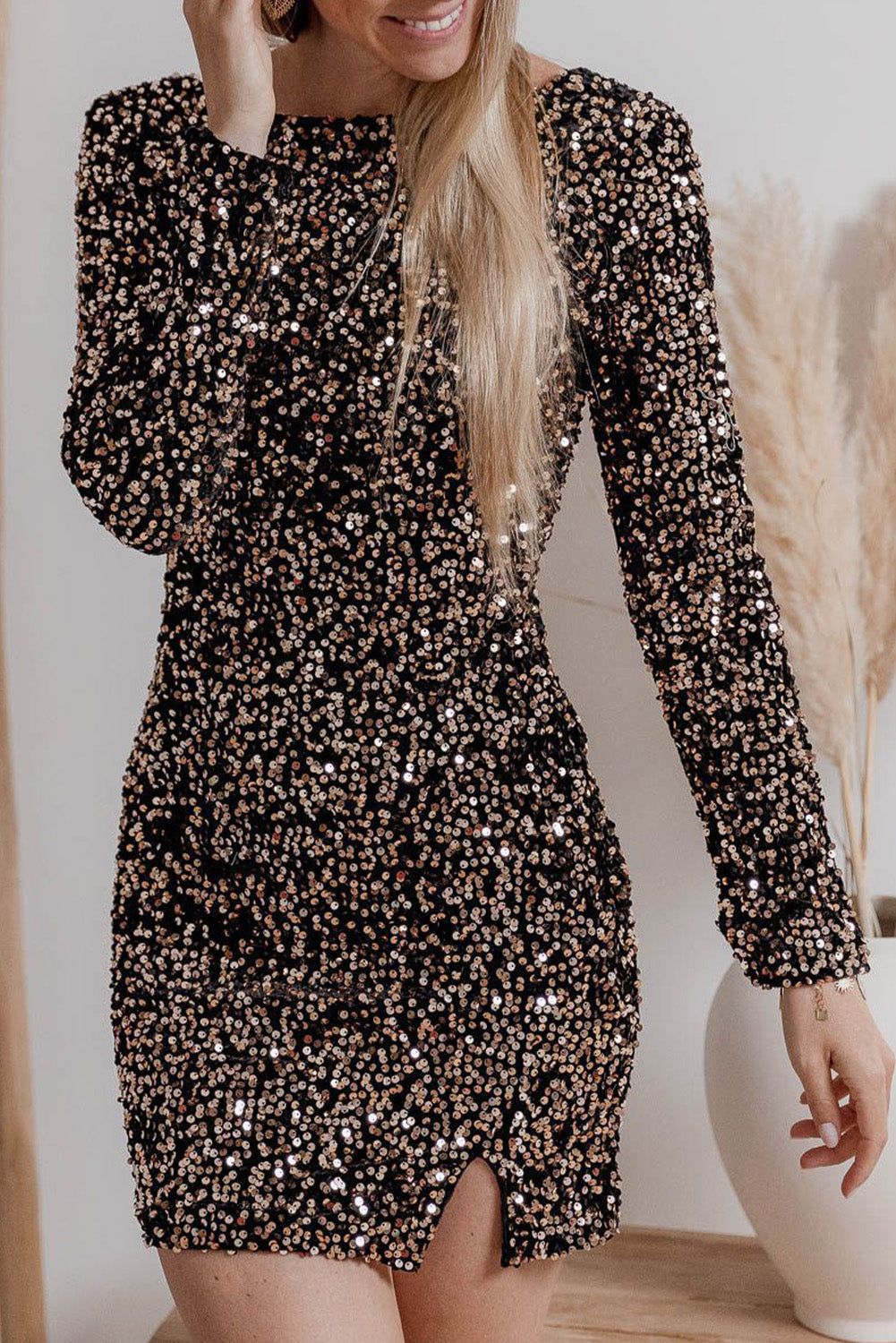 Een prachtige feestjurk bedekt met fonkelende pailletten, perfect voor een glamoureuze uitstraling. De jurk heeft lange mouwen en een elegante ronde halslijn, terwijl de split aan de voorkant een verfijnde touch toevoegt. Deze jurk is ideaal voor een chique avond uit of speciale gelegenheid.