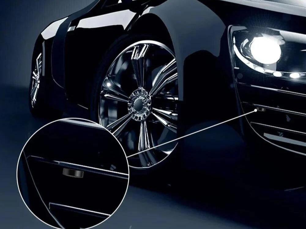 Orbitron GPS Tracker met krachtige magnetische bevestiging, bevestigd aan een voertuig. De afbeelding toont de tracker die discreet is bevestigd aan de onderkant van een voertuigwiel, met een close-up van de magnetische bevestigingsplaats