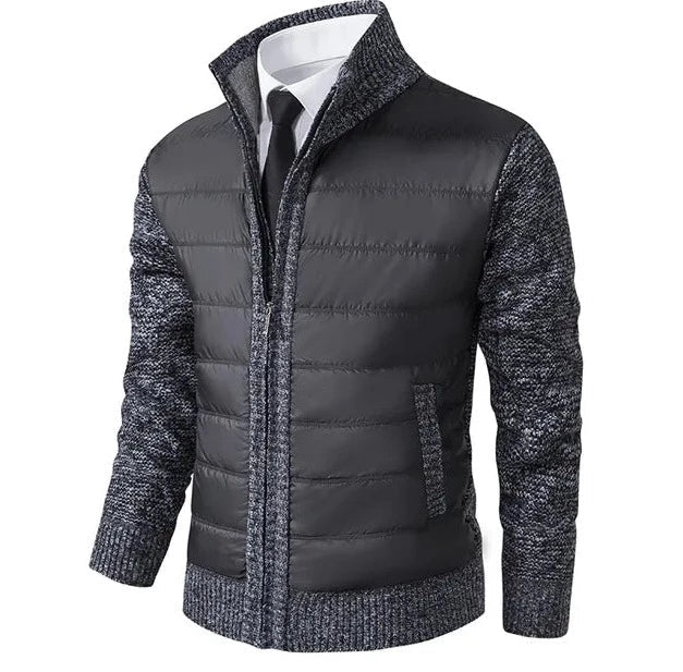 Grijs wintervest met gewatteerde panelen aan de voorkant en gebreide mouwen en zijkanten. Dit stijlvolle en comfortabele vest heeft een rits en een moderne uitstraling, ideaal voor de koude maanden. Perfect voor een casual, verfijnde look met extra warmte en bescherming.