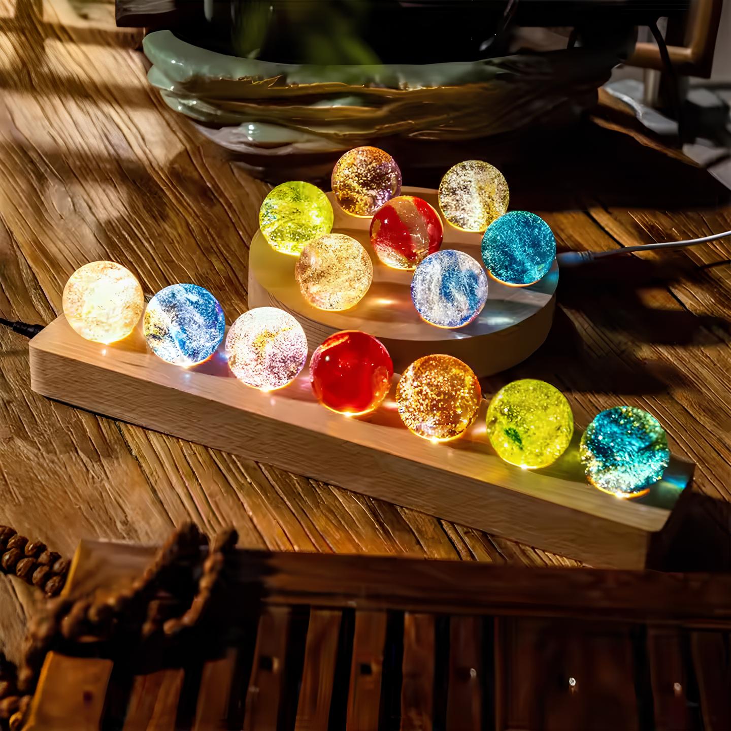 StarGlow lampen met kleurrijke kristallen bollen die licht uitstralen. De bollen in verschillende kleuren zoals rood, blauw, geel en groen zijn mooi gepositioneerd op een houten standaard, waardoor ze een magisch en betoverend effect creëren in de ruimte.