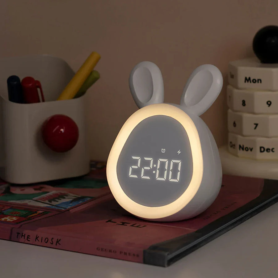 Urania alarmklok in schattig konijnontwerp met oortjes. De klok heeft een digitale LED-display en een zachte nachtlampfunctie. Perfect voor op een nachtkastje of bureau, ideaal voor kinderen en volwassenen.