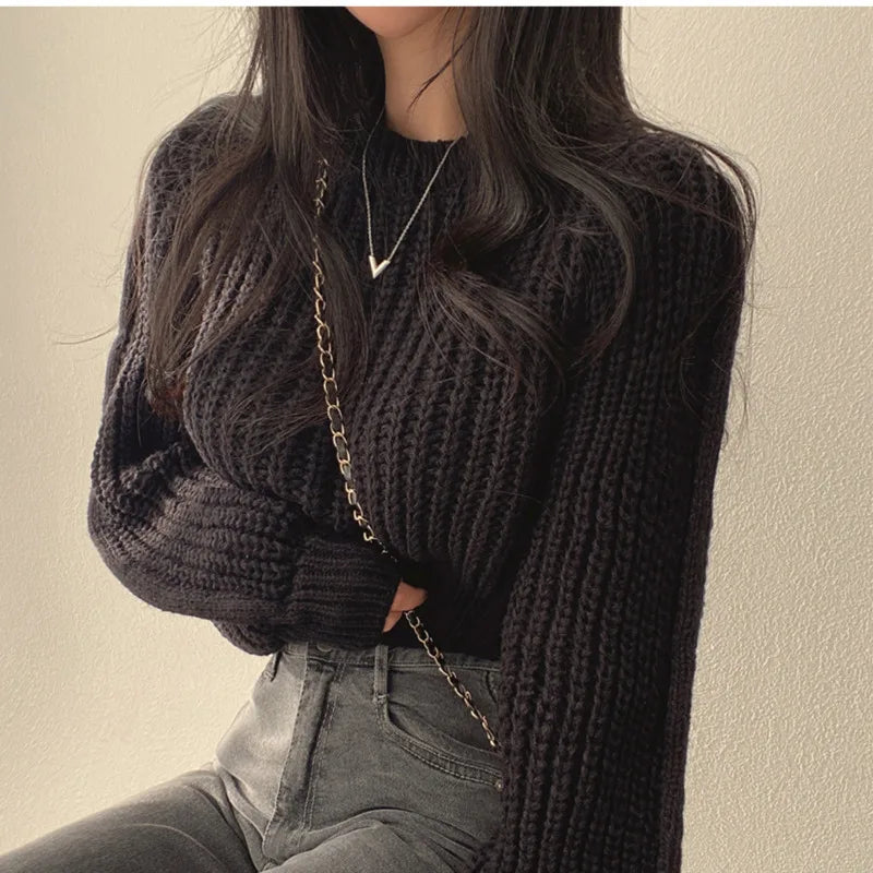 Model draagt een zwarte gebreide trui van Yvano. De trui heeft een grove structuur, lange mouwen en een casual oversized pasvorm, gecombineerd met een donkere jeans. De warme en stijlvolle uitstraling maakt deze trui perfect voor zowel dagelijkse als trendy looks. Yvano | Truien | Comfortabel.