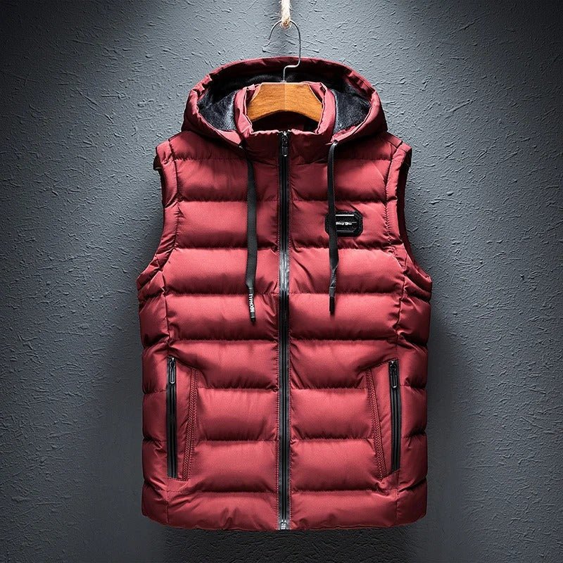 Een gewatteerde bodywarmer van ZachtKern in bordeauxrood, met een capuchon en handige zakken. Dit stijlvolle vest biedt zowel comfort als een modieuze uitstraling, ideaal voor koude dagen.