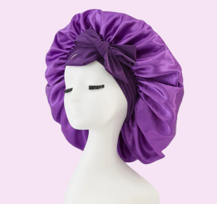 Zanara zijden slaapmuts in paars, ontworpen voor nachtcomfort en haarbescherming. De slaapmuts heeft een zachte, glanzende satijnen stof en een elegante strik aan de voorkant. Het elastische bandje zorgt voor een comfortabele pasvorm, ideaal om je haar te beschermen tegen beschadiging, uitdrogen of breken tijdens de nacht. Een luxe accessoire voor een gezonde haargroei en een goede nachtrust.