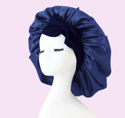 Zanara zijden slaapmuts in diepblauw, ontworpen voor ultiem nachtcomfort en bescherming van het haar. De luxe satijnen stof glanst zachtjes, terwijl het elastische bandje zorgt voor een comfortabele en veilige pasvorm. De slaapmuts heeft een elegante strik aan de voorkant en biedt bescherming tegen haarbeschadiging, uitdrogen of breken, ideaal voor een gezonde haargroei tijdens de nacht.