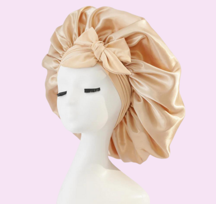 Zanara zijden slaapmuts in een elegante champagnekleur, ontworpen om je haar te beschermen terwijl je slaapt. De zachte, glanzende satijnen stof voorkomt beschadiging en pluizen, terwijl de elastische band zorgt voor een comfortabele, stevige pasvorm. De charmante strik voegt een verfijnde uitstraling toe, waardoor deze slaapmuts zowel functioneel als stijlvol is voor je nachtrust. Perfect voor het behoud van gezond, glanzend haar.