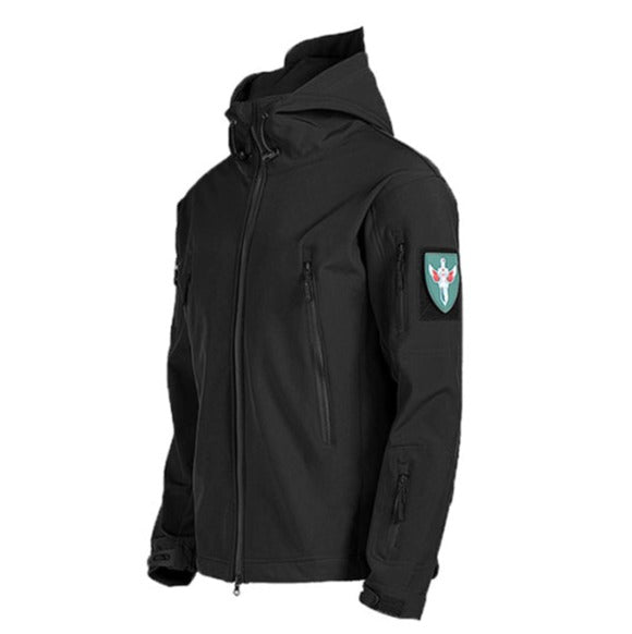 Een zwarte waterdichte regenjas met capuchon, ontworpen voor zowel stijl als functionaliteit. De jas heeft ritszakken aan de voorzijde en een militair geïnspireerd embleem op de mouw. Perfect voor regenachtige omstandigheden en buitenactiviteiten, met een moderne, slanke pasvorm.