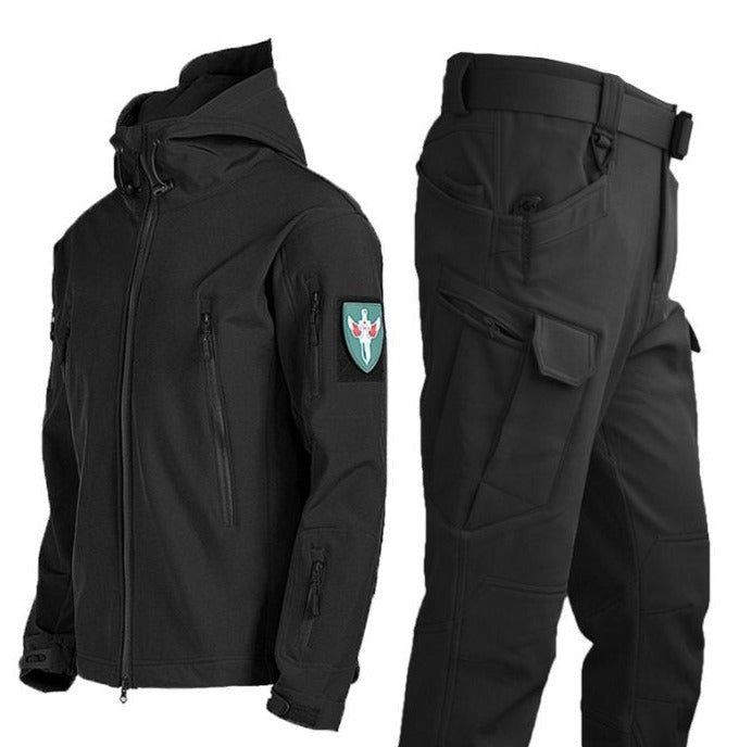 Een zwart waterdicht regenjack met bijpassende broek, ontworpen voor zowel stijl als functionaliteit. Het jack heeft een capuchon en meerdere ritszakken, terwijl de broek een moderne uitstraling heeft met praktische zakken. Dit regenpak biedt bescherming tegen het weer en is perfect voor outdoor activiteiten of dagelijkse avonturen.