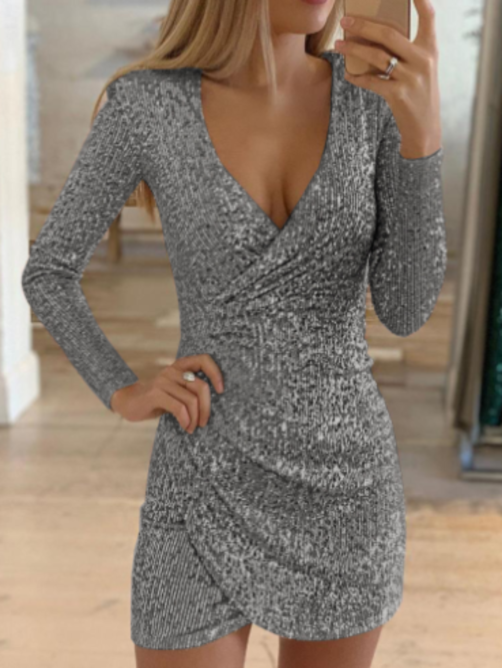 Deze grijze paillettenjurk van Zephyrine biedt een verfijnde en glamourachtige uitstraling. Met een V-hals en lange mouwen geeft de jurk een elegante en flatterende pasvorm. Het glinsterende ontwerp maakt het de perfecte keuze voor een speciale gelegenheid of een feest, waarbij je gegarandeerd alle ogen op je gericht hebt.