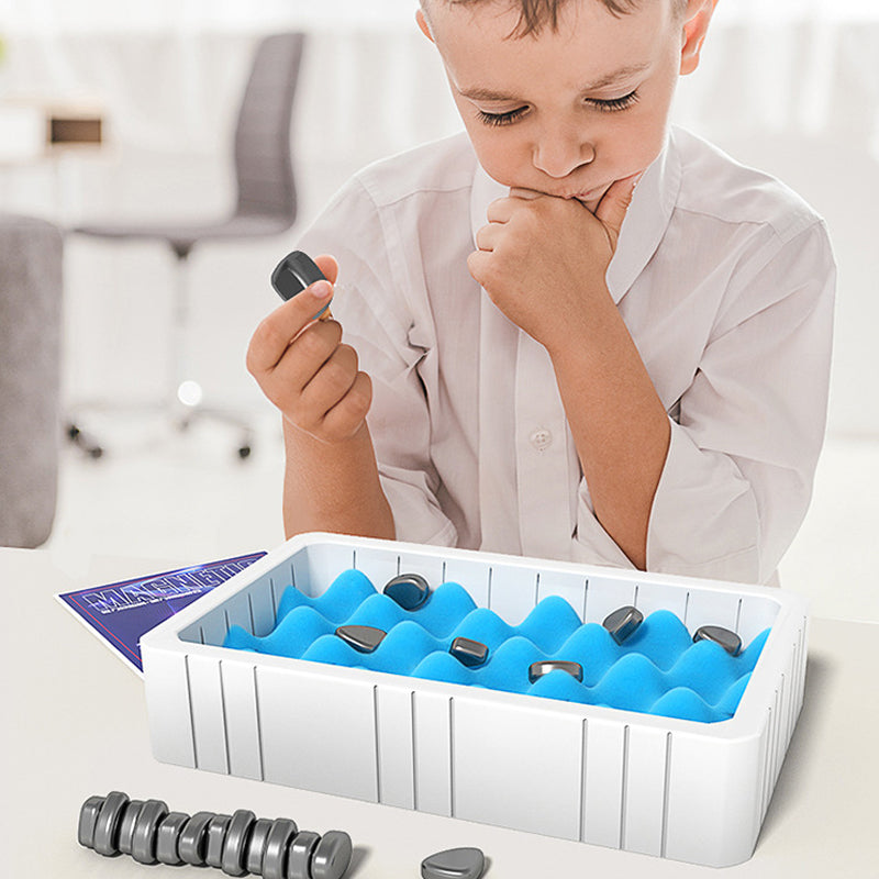 Een kind in een wit overhemd speelt met een magnetisch schaakspel. De stukken zijn geordend in een wit doosje met blauwe kussentjes om ze op te bergen, terwijl het kind geconcentreerd een stuk in zijn hand houdt, klaar om te verplaatsen. De foto toont het educatieve en interactieve karakter van het Zevano Magnetisch Schaakspel.
