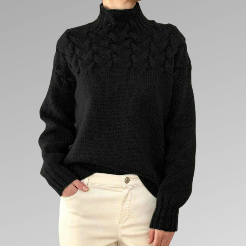 Zimora veelzijdige casual trui in zwart, met een elegant gevlochten patroon rond de schouders en een hoge kraag. De trui heeft een comfortabele pasvorm met lange mouwen, perfect voor een stijlvolle en warme uitstraling. Ideaal om te combineren met lichte broeken of jeans voor een casual-chique look.